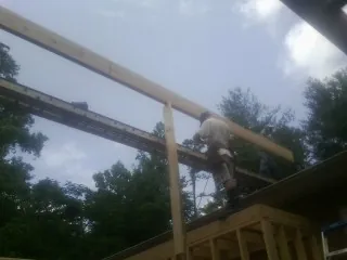 Carpenter setting a ridge beam over a new addition frame — Ice Dam Removal by Roofing Brothers in Brookshire
