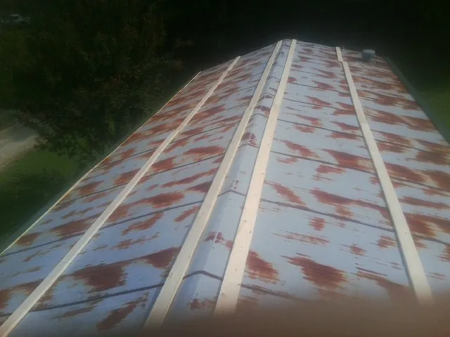 Rusted metal roof panels with new wood purlins before replacement — Storm Damage Roof Repair in Brookshire by Roofing Brothers