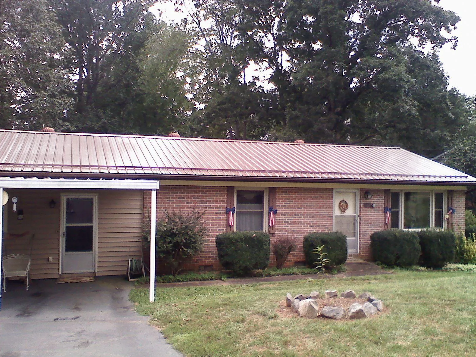 Bronze metal roof and carport on a brick ranch home — Roof Repair work by our crew in Brookshire